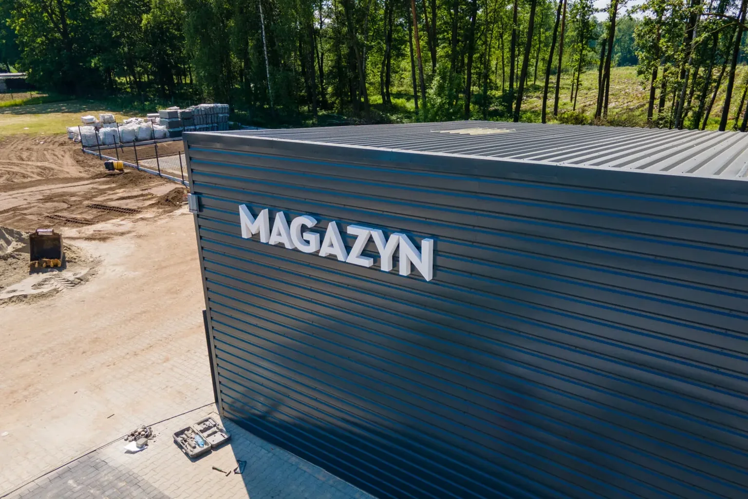 Wnętrze hali magazynowej z regałami i stanowiskami pakowania zamówień